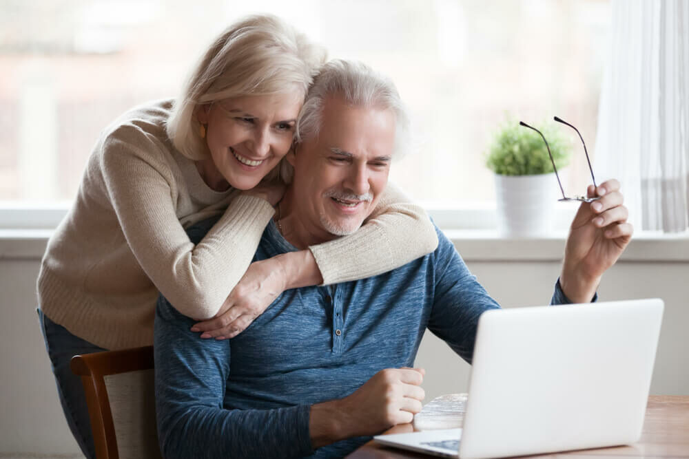 Couple embracing using a laptop